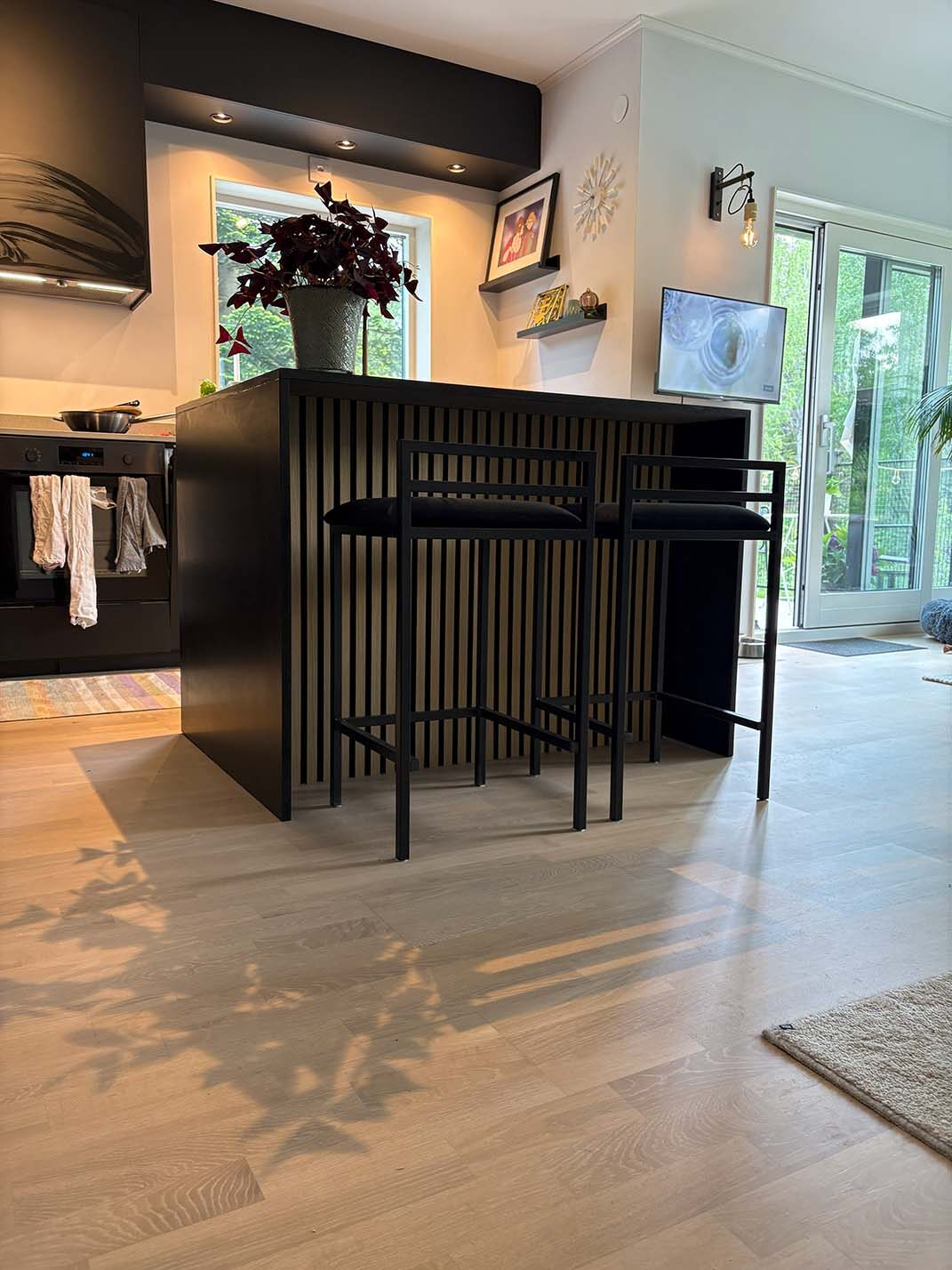 Köksö med barstolar och svart front