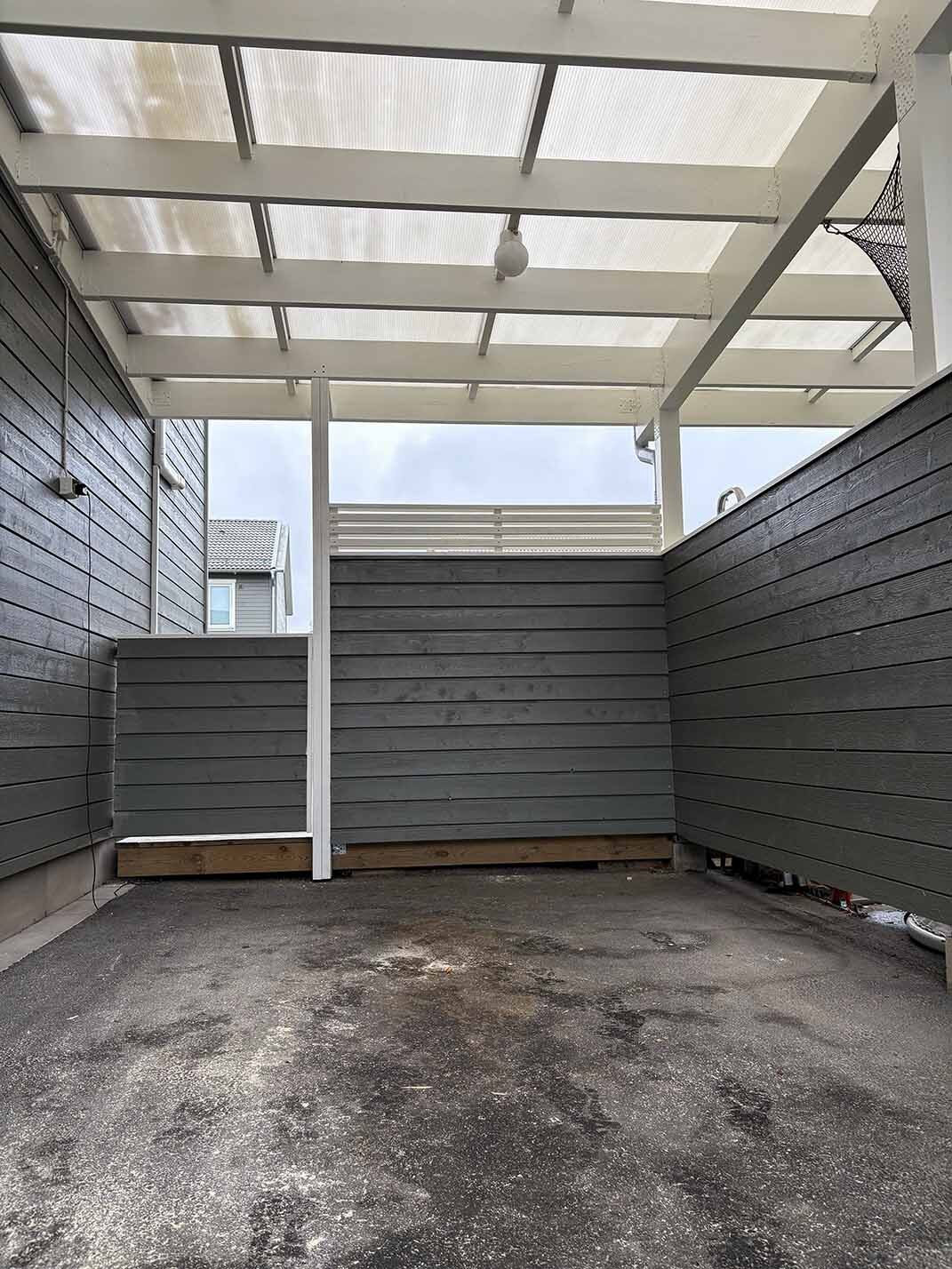 Carport med tak och grå panel